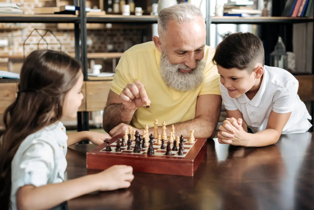 A grandparent teaching their grandchild to play chess
